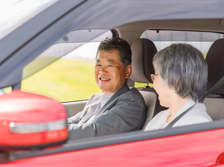 赤い車に乗っている老夫婦